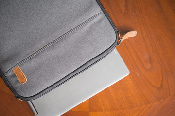 laptop sitting on wooden table with case and glasses. good for a writer, editor, author or entrepreneur. 