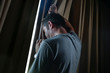 © TheVisualsYouNeed - dramatic light portrait of young sad and depressed attractive man at home looking through room window thoughtful and pensive lost in pain broken heart suffering depression