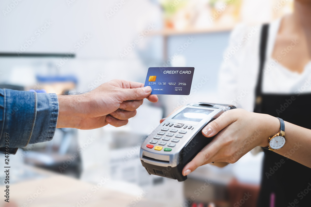 Customer using credit card for payment to owner at cafe restaurant, cashless technology and credit card payment concept - obrazy, fototapety, plakaty 