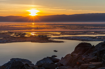 Beautiful bright tranquil landscape of spring Baikal Lake. View from Olkhon Island to the setting sun over the Small Sea Strait