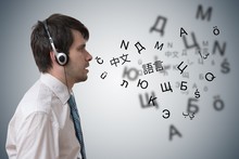 Young Man With Headphones Is Learning Different Foreign Languages.