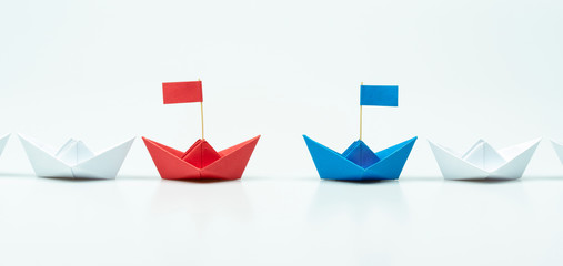 Competition of two leaders concept with Blue and red paper ship leading among white on white background