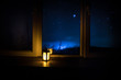© zef art - Night scene of stars seen through the window from dark room. Night sky inside dark room. Long exposure shot