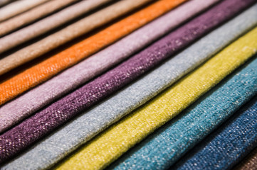 Colorful and bright fabric samples of furniture and clothing upholstery. Close-up of a palette of textile abstract stripes of different colors