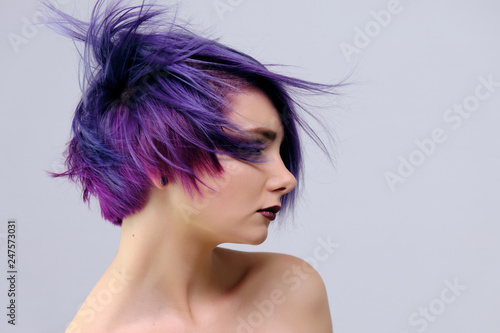 A Beautiful Sexy Girl With Purple Hair And A Short Haircut Sits