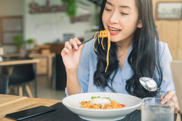 Spaghetti on a fork. Girl keeping fork with spaghetti.  Young woman eating Italian pasta.