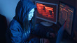 © Artem - Girl hacker in a hood typing program code while committing a cybercrime hacking a firewall on the background of screens