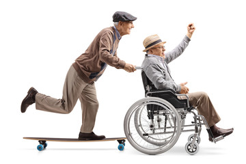 Poster - Elderly man on a longboard pushing a man with raised hand in a wheelchair