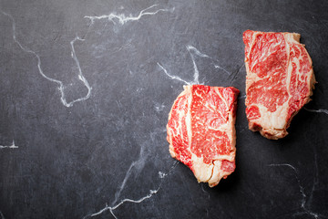 Wall Mural -  Raw Fresh Marbled Meat Beef Steak on the black marble Background Top View Copy space for Text