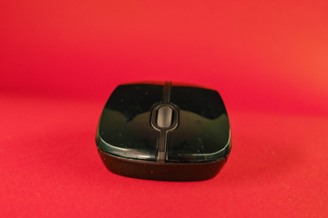 black computer mouse on a red background