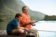 © Erickson Stock - Father and son enjoying fishing together at the lake.