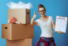 Woman Near Cardboard Box Showing Moving Checklist And Thumbs Up