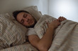 Portrait of dressed adult male fell asleep in bed with the phone in hand as a result of tiredness/ social media addiction, exhausted man, accumulated fatigue, not enough sleep, healthcare concept.