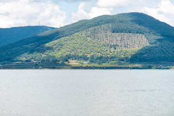 Poster - Green summer park in Punta del Lago with Vico lake Terni province nobody landscape day view of blue water and mountain peaceful