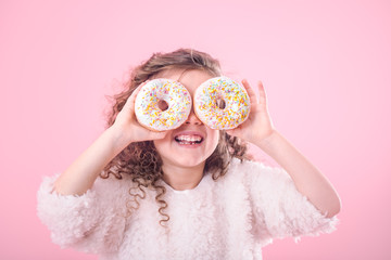 Portrait of a little smiling girl with donuts