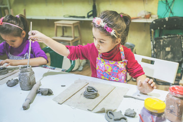 Wall Mural - Portrait of little artist working with clay