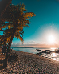 Wall Mural - Beautiful sunset in Trou aux Biches, Mauritius. View of the jetty and boats amidst palm trees