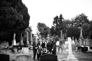 Wall Mural - Sad family standing at a cemetery