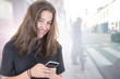 © OceanProd - lifestyle pretty woman in street texting with smartphone