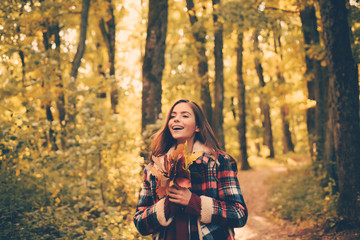 Cheerful beautiful girl in red sweater outdoors on beautiful fall day. Autumnal mood. Romantic Young Woman on Natural Background Outdoors. Portrait of beautiful caucasian woman walking outdoors.