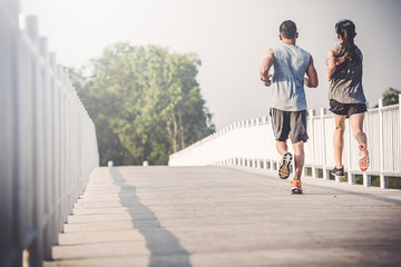 Wall Mural - young couple runner running on running road in city park