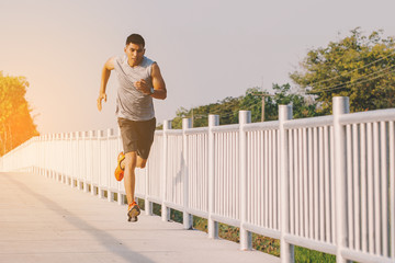 Wall Mural - young man runner running on running road in city park