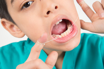 Poster - Little boy using dental floss to clean tooth