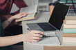 © LIGHTFIELD STUDIOS - selective focus of woman holding pen near notebook and laptop