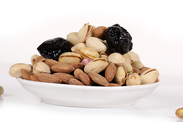 Wall Mural - Assorted nuts on white, dry fruits, mix nuts, roasted almond, prunes, pistachio