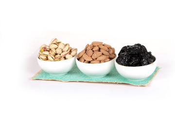 Wall Mural - Assorted nuts on white, dry fruits, mix nuts, roasted almond, prunes, pistachio