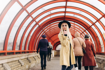 Street fashionable close up portrait of young hipster girl in yellow suit and black hat outdoors