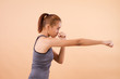 © 9nong - serious asian woman fighting; portrait of woman punching, martial arts, karate, kungfu, mma, boxing training, workout, exercising for healthy lifestyle concept; tan skin asian young adult woman model