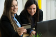 © Daniel - Two beautiful business woman shopping online in office