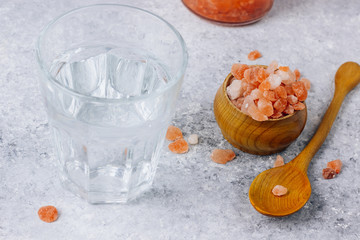 water in a glass and Himalayan salt isolated on white background