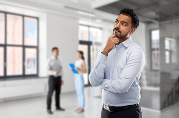 Poster - business, realty and people concept - indian businessman or realtor over empty office room background