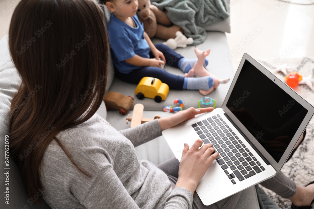 Young mother with her son working at home