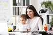 © Pixel-Shot - Young mother with her son working in office