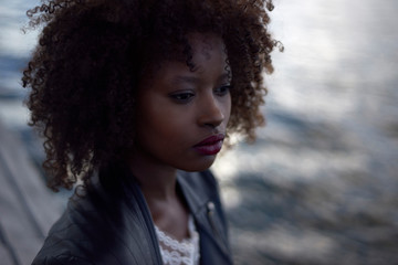 Wall Mural - Beautiful black woman wearing headphones in urban city setting during sunrise