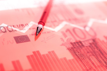 Finance background with money, stock market chart, graph and pen. Living coral toned.