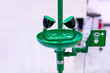green emergency eye washing station equipment with safety signage unit for chemical accident or critical with copy space