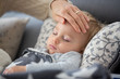 © Tomsickova - Sick child, toddler boy lying in bed with a fever, resting at home