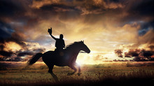 A Silhouette Of A Cowboy And Horse At Sunset
