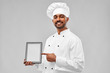 cooking, technology and people concept - happy male indian chef in toque with tablet computer over grey background