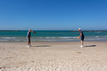 Wall Mural - Men of different generations play beach tennis