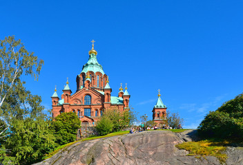 Wall Mural - Helsinki, Finland. Uspenski Orthodox Cathedral on the top of the rock in a sunny summer day with green vegetation