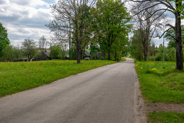 empty country gravel road with mud puddles and bumps