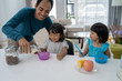 © Odua Images - asian dad having breakfast with his two little girl in the morning at home