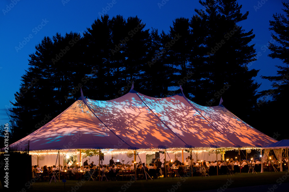 Wedding tent at night - Special event tent lit up from the inside with dark blue night time sky and trees - obrazy, fototapety, plakaty 
