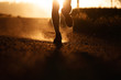 © Tandem Stock - Low section of male athlete running on road during sunset