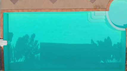 Canvas Print - Aerial Drone footage above pool with clear blue water and palm trees shadows and girl lies on sunbed